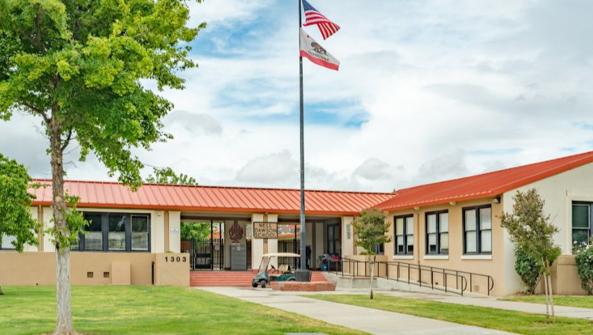 California school campus building framed by mature trees